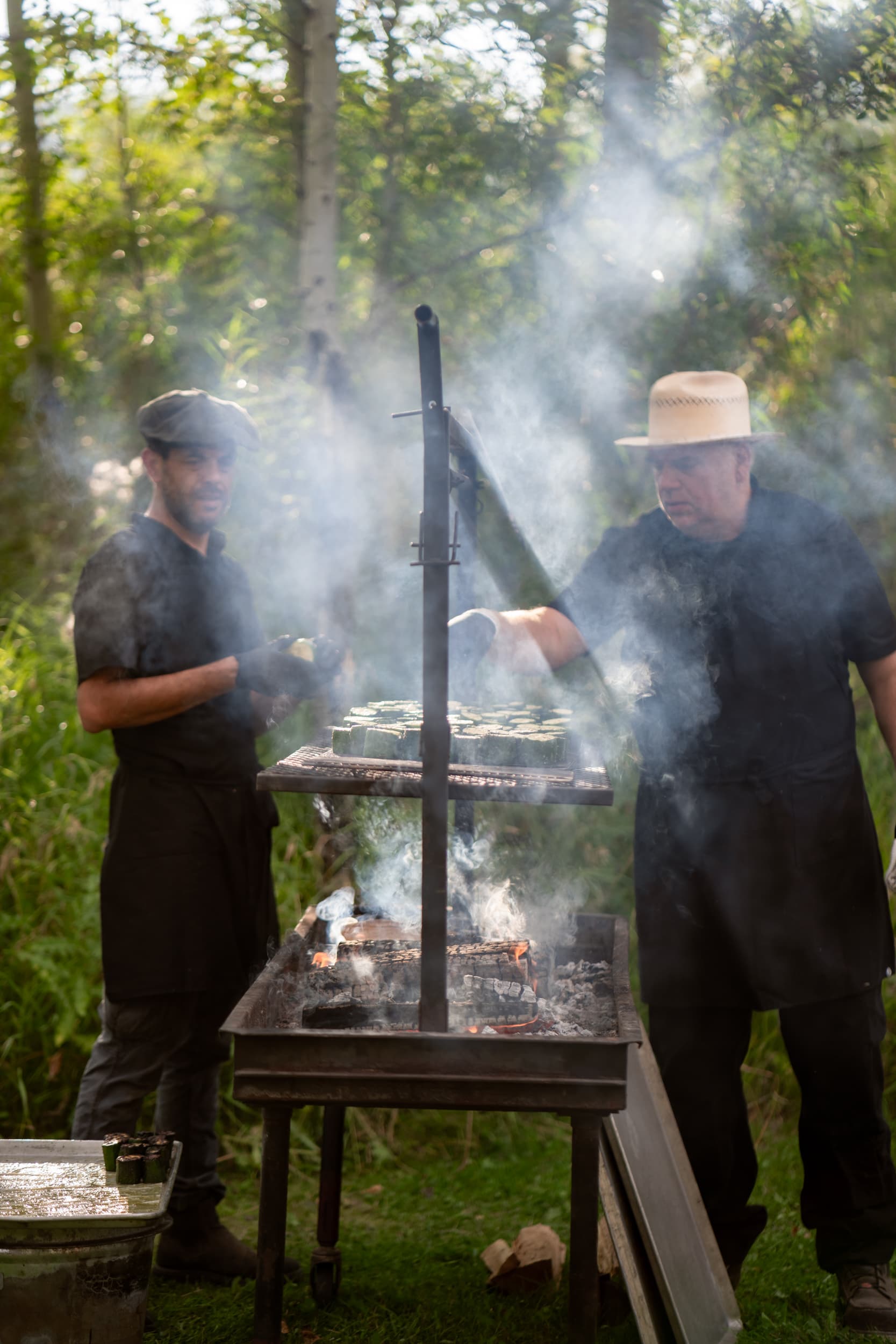 Chefs preparing farm-to-table cuisine over open fire