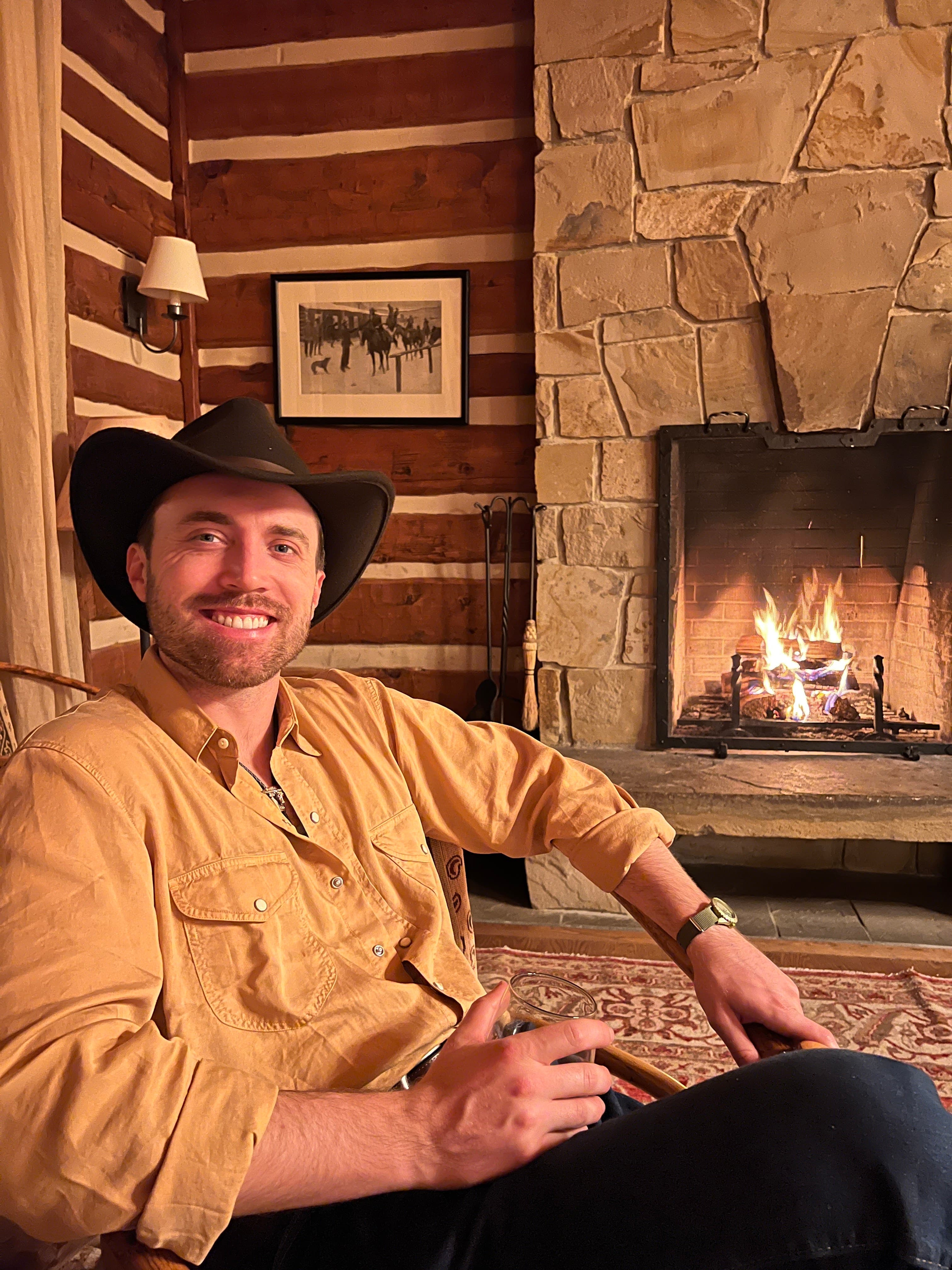 Guest relaxing by stone fireplace in cabin